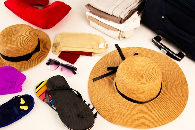 Accesorios de playa equipaje artículos de viaje maleta y sombrero preparándose para vacaciones o viajes