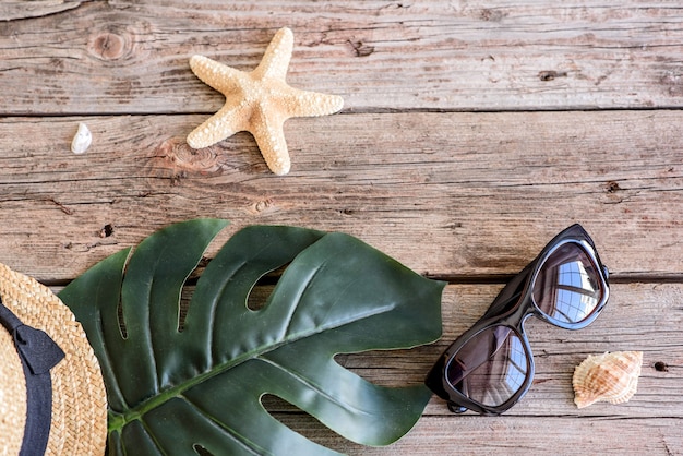 Accesorios de playa: gafas y sombrero con conchas y estrellas de mar. Fondo de verano