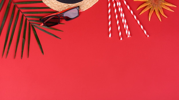 Accesorios de playa: gafas y sombrero con conchas y estrellas de mar sobre un fondo de color. Fondo de verano