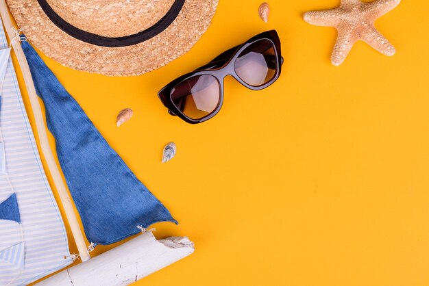 Foto accesorios de playa: gafas y sombrero con conchas y estrellas de mar.