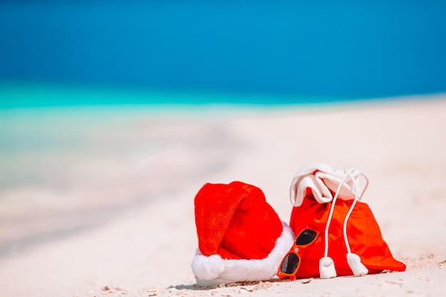 Accesorios de playa con gorro de Papá Noel en playa tropical blanca