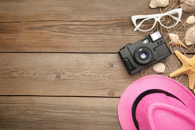 Accesorios de playa con gorro rosa sobre gris