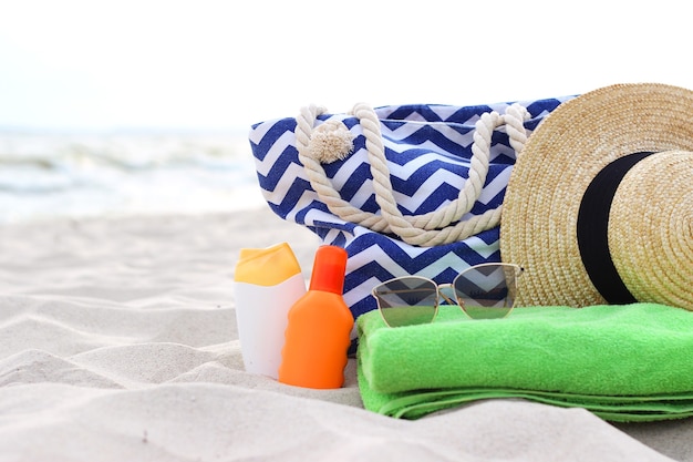 Foto accesorios de playa y protectores solares en la arena del mar