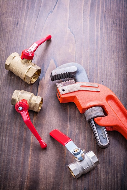 Accesorios de plomería y llave ajustable en tablero de madera vintage