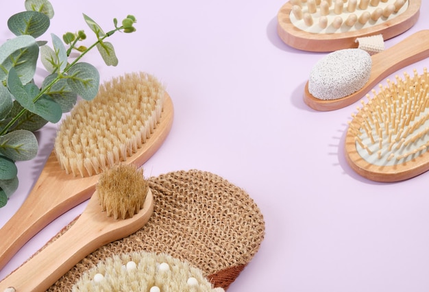 Accesorios para spa y baño en mesa Producto de limpieza y cuidado Copiar espacio para texto Pincel para ducha y masaje de madera sobre un fondo púrpura