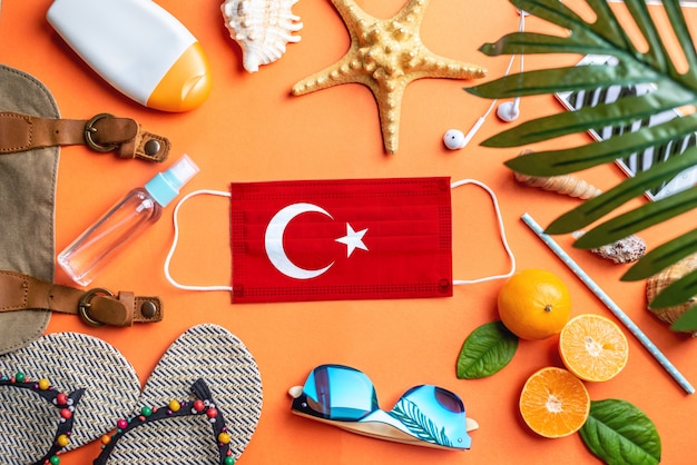 Accesorios para vacaciones en la playa alrededor de una máscara protectora con la bandera de Turquía
