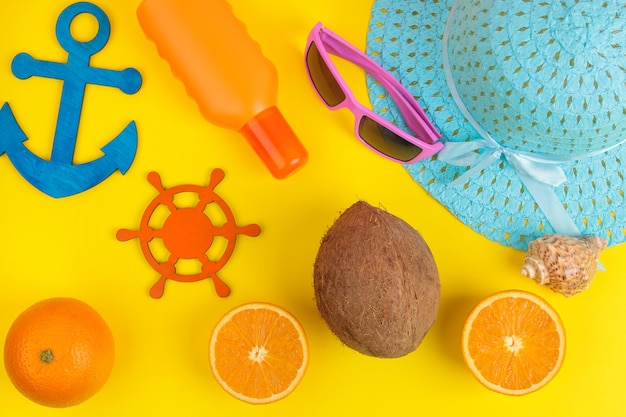 Accesorios de verano. accesorios de playa. bloqueador solar, sombrero, coco, naranja y lentes