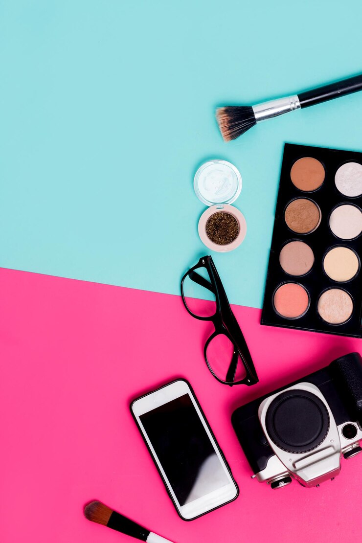 Foto accesorios de viaje planos para mujer sobre fondo azul y rosa colorido con cosméticos, teléfono inteligente, anteojos y cámara. primer plano, vista superior, espacio de copia