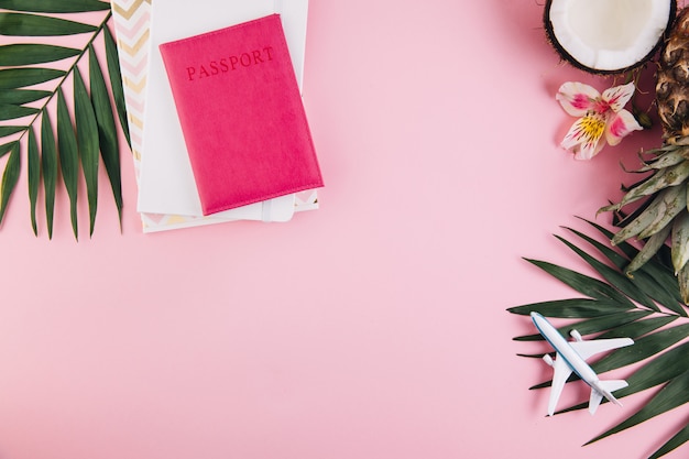 Accesorios del viajero y frutas tropicales en fondo rosado de moda. Brillante color veraniego.