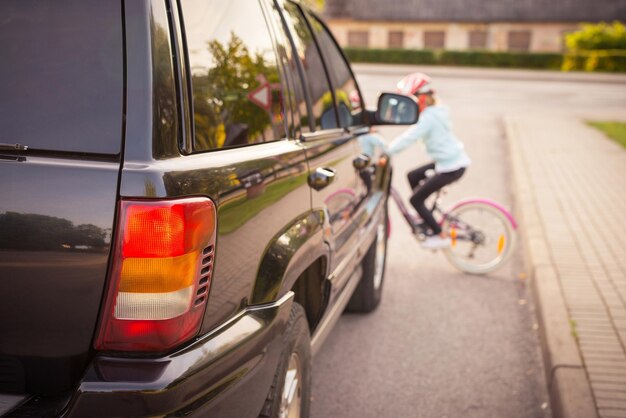 Accident Girl en la bicicleta cruza la calle frente a un auto