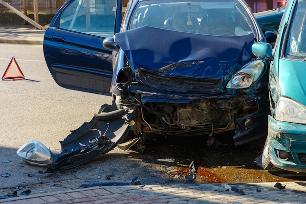 Accidente automovilístico Un automóvil de pasajeros averiado está en la carretera después de un accidente Señal de tráfico de una parada de emergencia Seguro de accidentes en la carretera