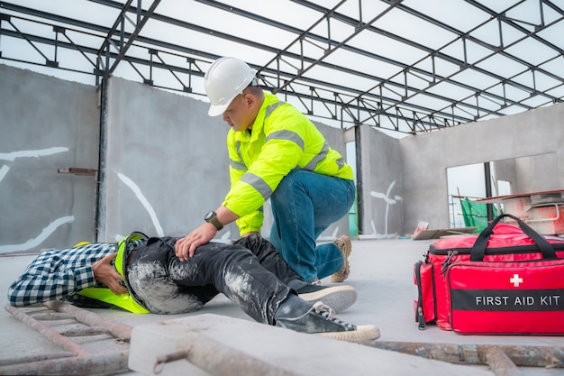 Foto accidente en obra. lesión física en el trabajo del trabajador de la construcción. primeros auxilios ayude a un trabajador de la construcción que tuvo un accidente en el sitio de construcción. primeros auxilios ayuda en caso de accidente en obras de construcción.