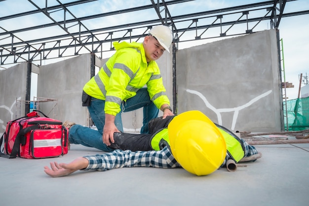 Accidente en obra. Lesión física en el trabajo del trabajador de la construcción. Primeros auxilios Ayude a un trabajador de la construcción que tuvo un accidente en el sitio de construcción. Primeros auxilios Ayuda en caso de accidente en obras de construcción.