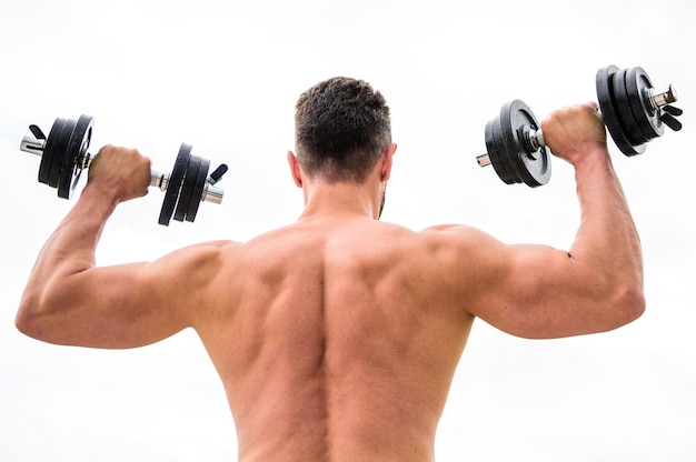 Las acciones hablan más que los entrenadores Gimnasio de ejercicios con mancuernas Hombre musculoso haciendo ejercicio con vista trasera con mancuernas Deportista con espalda y brazos fuertes Equipo deportivo Deporte de culturismo Estilo de vida deportivo