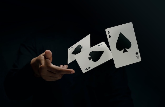 Foto ace spade jogador de cartas ou mágico flick e levitating poker card com a mão front view closeup e tone escuro