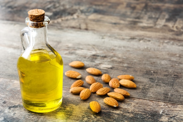 Foto aceite de almendras en botella en mesa de madera