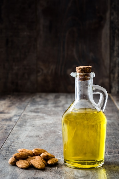 Aceite de almendras en botella en mesa de madera