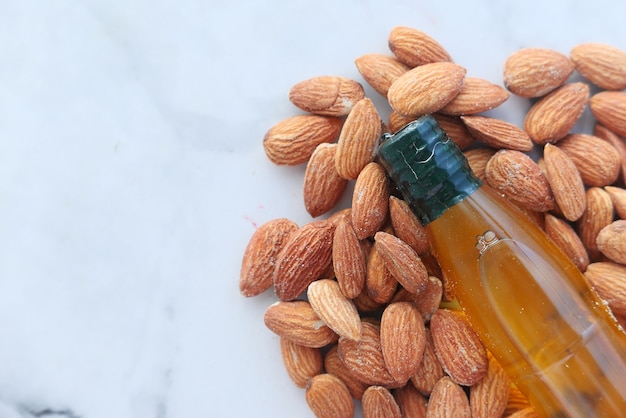 Aceite de almendras en botella sobre fondo de madera. De arriba hacia abajo