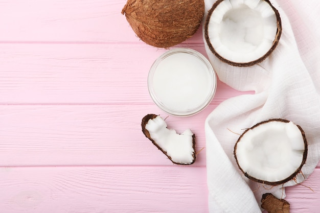 Aceite de coco y cocos en la mesa.