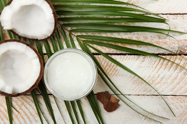 Aceite de coco y cocos en la mesa.