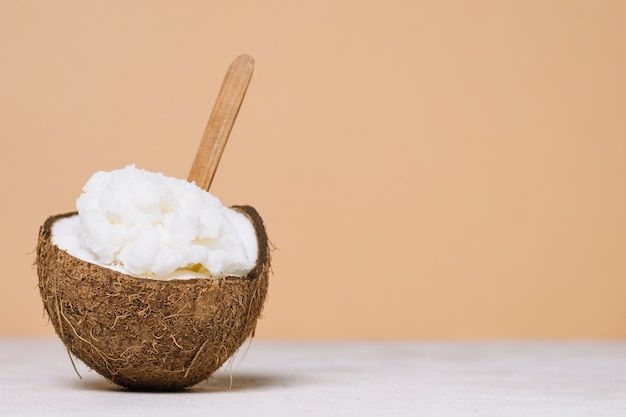 Aceite de coco en un tazón de coco con espacio de copia