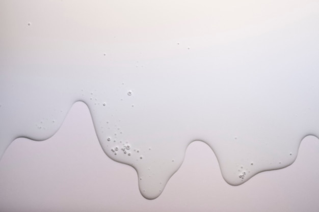 Aceite cosmético o emulsión sobre fondo gris