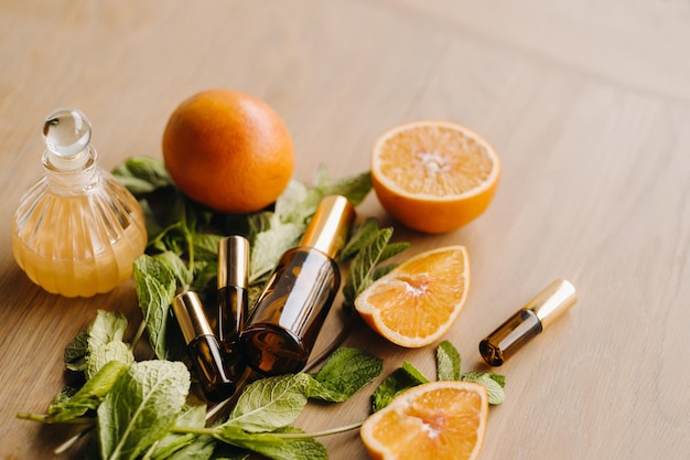 Aceite esencial en botellas con aroma de naranja y menta sobre una superficie de madera