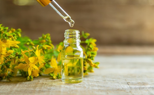 Aceite esencial de hierba de San Juan en una botella pequeña. Enfoque selectivo.