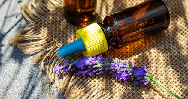 Aceite esencial de lavanda en una botella pequeña. Enfoque selectivo.