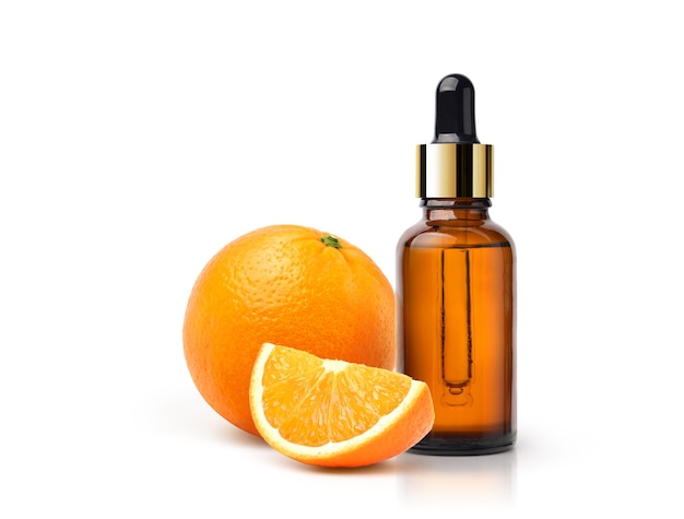 Aceite esencial de naranja con fruta naranja y en rodajas aislado sobre fondo blanco.