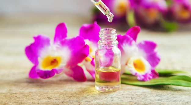 Aceite esencial de orquídea en una botella pequeña. Enfoque selectivo.