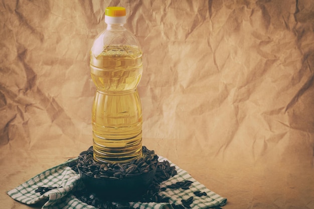 Aceite de girasol con una bolsa de semillas y una cuchara de madera.