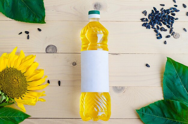 Aceite de girasol con flor y semillas en una botella.