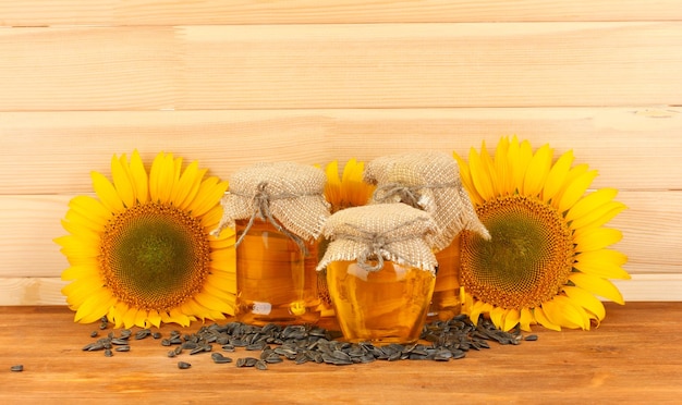 Aceite de girasol y girasol sobre fondo de madera