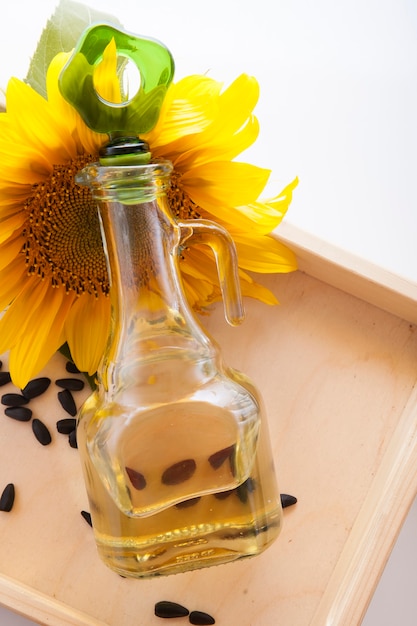 Foto aceite de girasol en una jarra transparente con flor de girasol