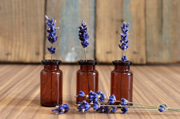 Foto aceite de hierbas y flores de lavanda sobre fondo de madera