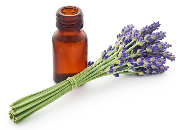 Aceite de lavanda con flor sobre fondo blanco.