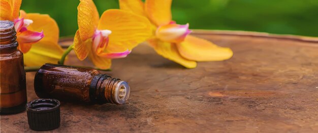 Aceite de masaje y piedras con orquídea amarilla