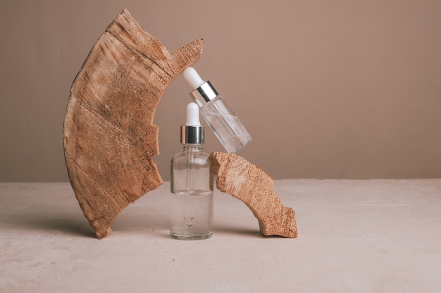 Foto aceite mineral ecológico en botellas de vidrio con pipeta y madera natural sobre fondo marrón