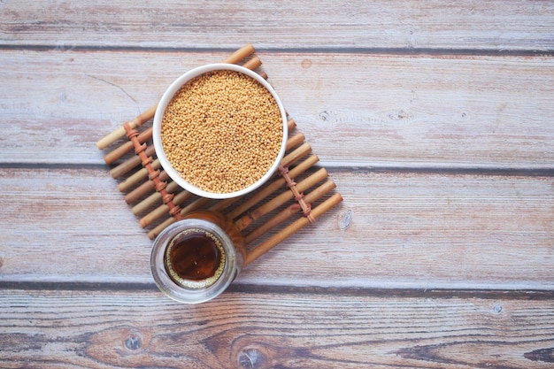 Aceite de mostaza y semilla cruda en frasco sobre mesa