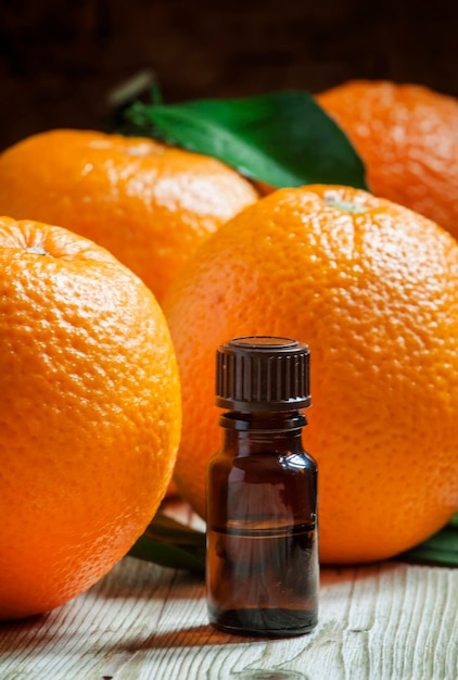 Aceite de naranja en una botella pequeña y enfoque selectivo de fruta fresca