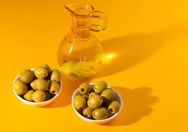 aceite de oliva y aceitunas sobre fondo amarillo