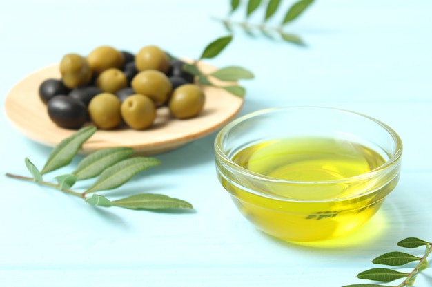 Aceite de oliva hojas verdes y aceitunas en la mesa