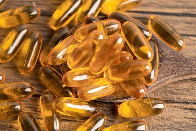 Aceite de pescado Omega 3 cápsulas de vitamina con EPA y DHA aislado sobre fondo de madera