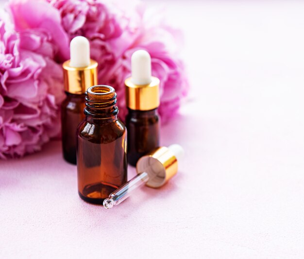 Aceites esenciales de aromaterapia y peonías rosas.