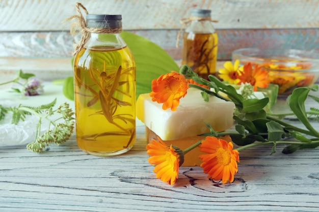Aceites y tinturas de jabón de flores de caléndula sobre un fondo de madera ingredientes naturales