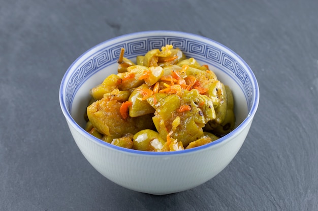 Aceituna en escabeche en un tazón en la mesa de piedra.