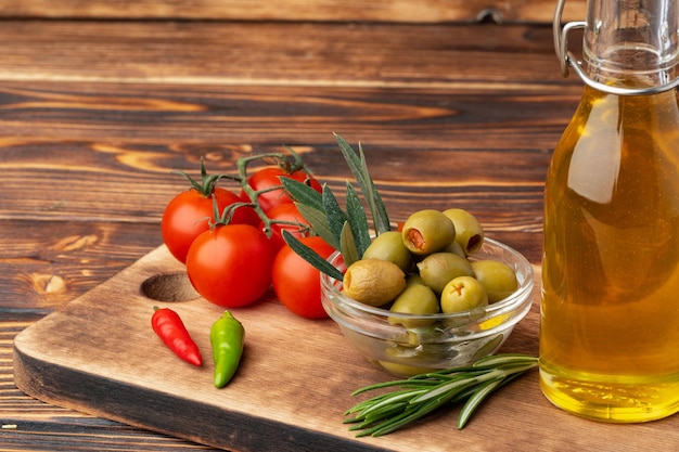 Aceitunas de aceite de oliva y tomates sobre fondo de madera