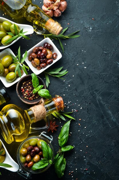 Aceitunas Un conjunto de aceitunas de colores sobre un fondo de piedra negra Vista superior Espacio libre para el texto
