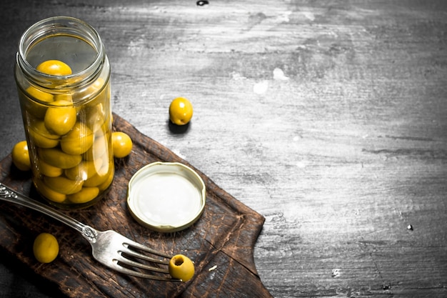 Aceitunas en escabeche en tarro. En la pizarra negra.